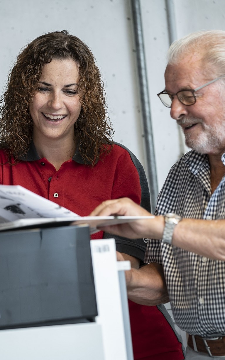 Eine ELCO Servicetechnikerin zeigt einem Kunden etwas in einer Broschüre